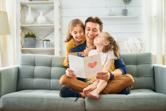 Father reading card with daughters