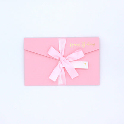 Pink pocket birthday greeting card with pink ribbon and white name tag